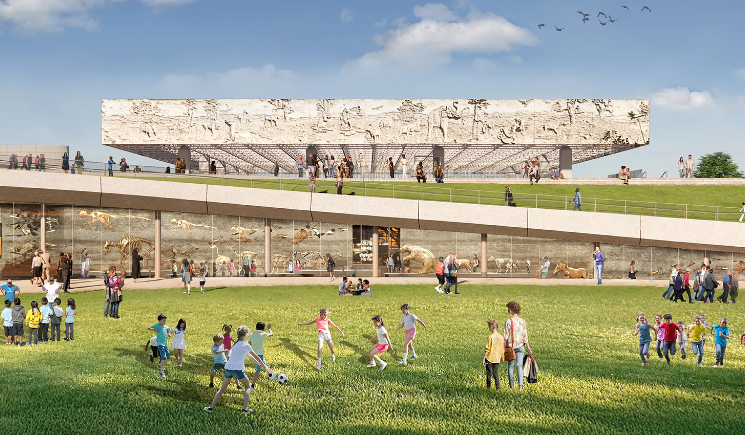 Visitors on a green lawn with a glass-walled gallery and ramp in the background