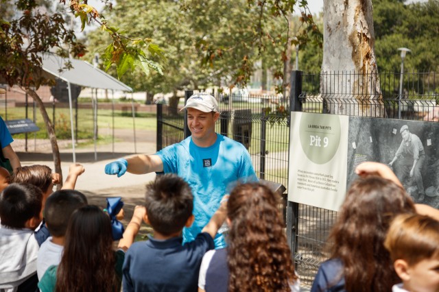 employee with kids on a tour at the tar pits