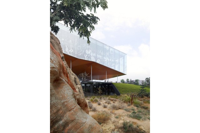 The existing building is opened up to the park with slits in the landscape that gives light in and views outwards. Above, a Pleistocene mural appears in solar pixels. 