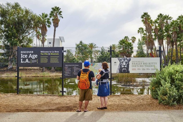 family standing in front of lake pit at la brea tar pits