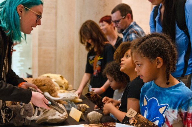 girls talking to scientist with fossil