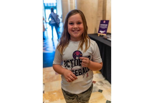 girls holding round sticker smiling