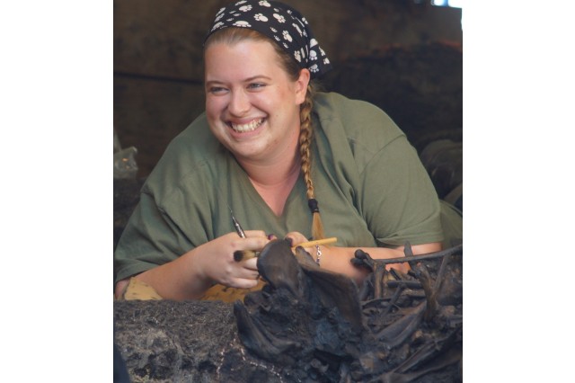 Senior Fossil Preparator Laura Tewksbury with a block of asphalt