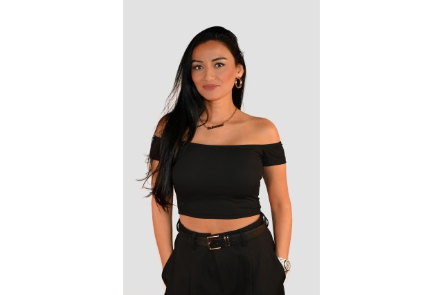 Dr. Samson wearing a black off the shoulder top with her hands in her pockets