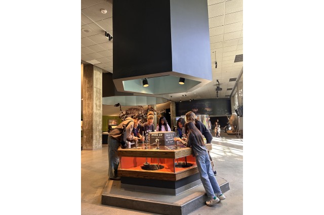 Students gathered around and looking down into a circular display