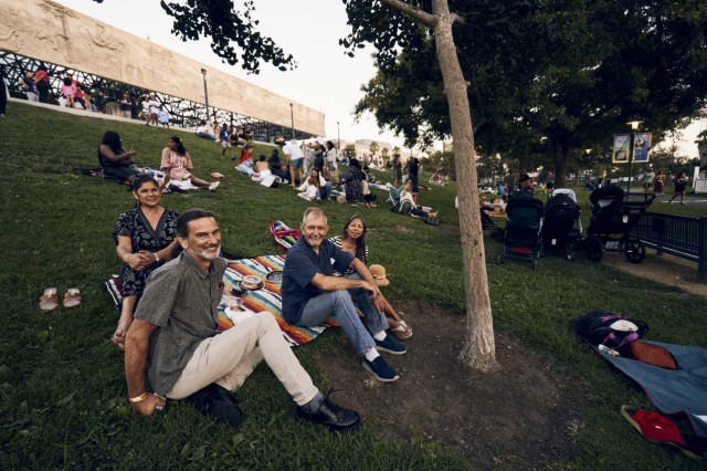 Visitors sitting on blankets on a grassy hill