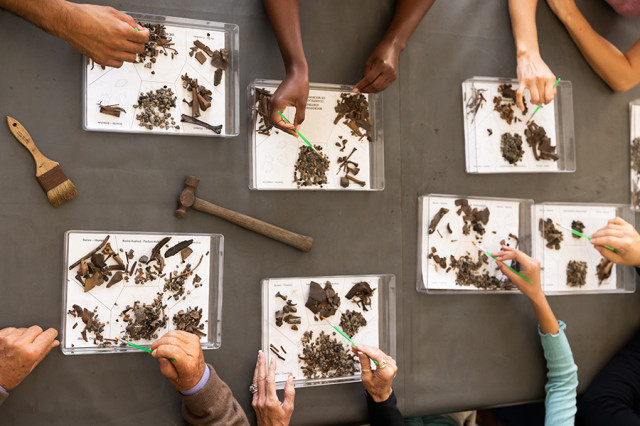 Close up of hands over trays of micro fossils