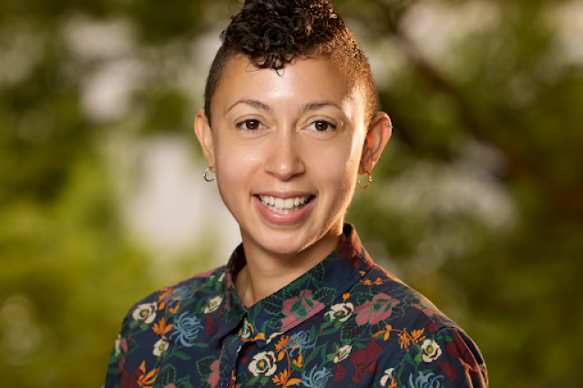 Dr. Christine Wilkinson smiling and wearing a flower-patterned button-up shirt