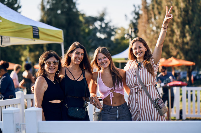 Women with their arms around each other and one holding up a peace sign with her fingers