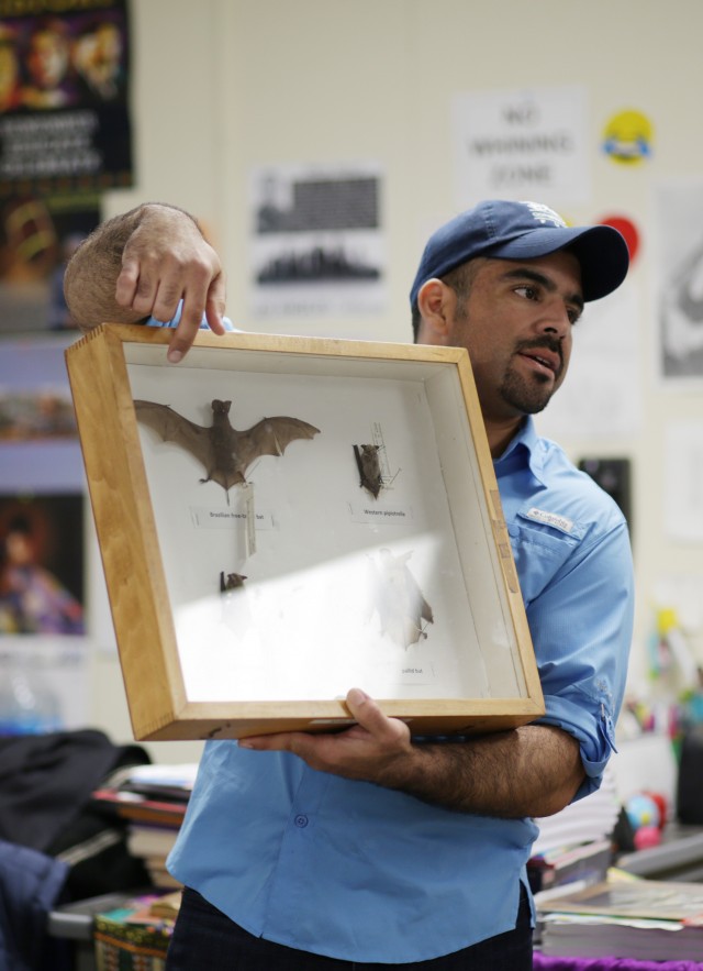 Miguel Ordeñana holds up a box of bat specimens.