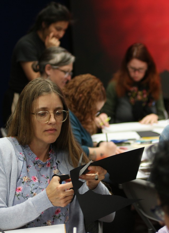 A teacher in the Tar Pits Educator Workshop: Paleo Puppetry cuts out her sabertooth-cat puppet