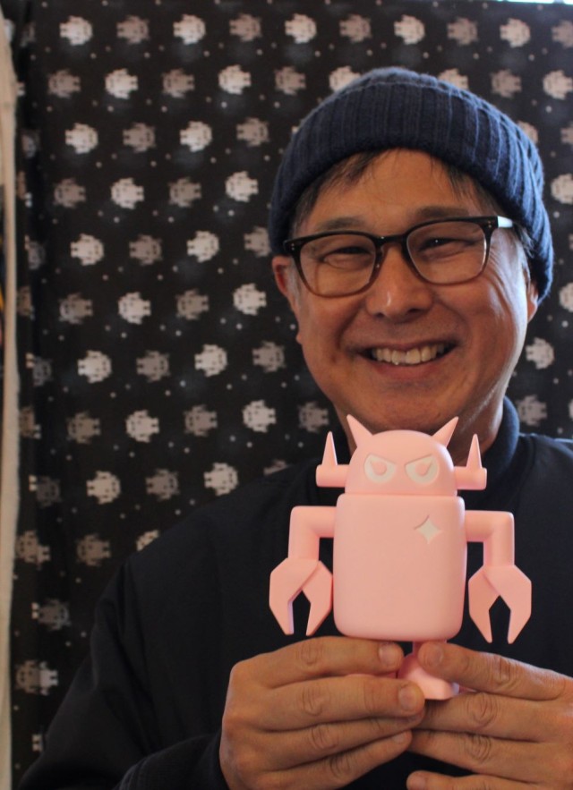Man holding pink robot figurine