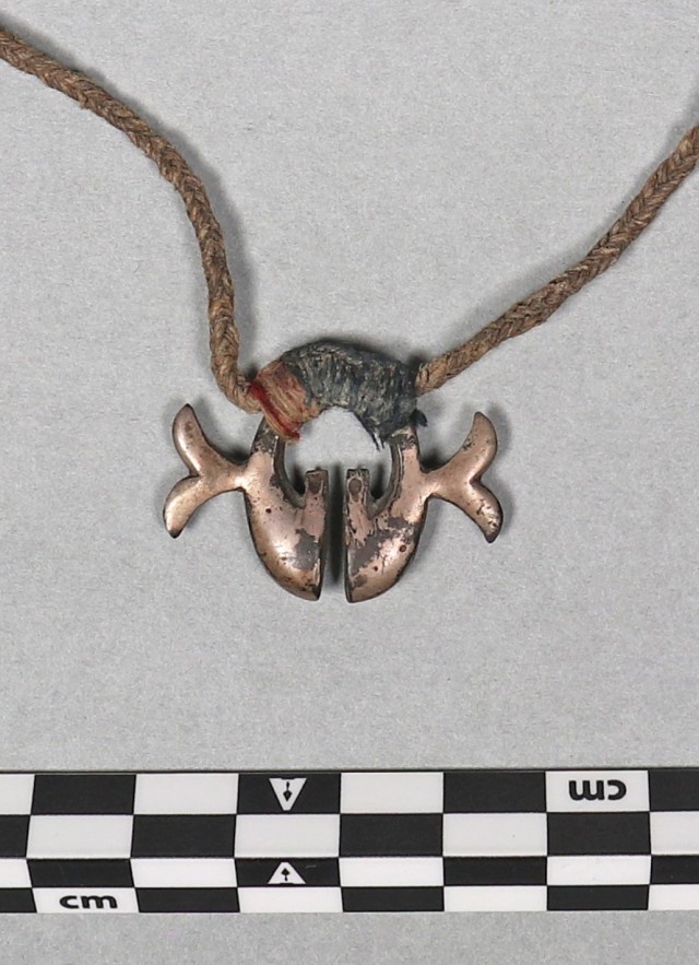 amulet with natural fiber strung through 