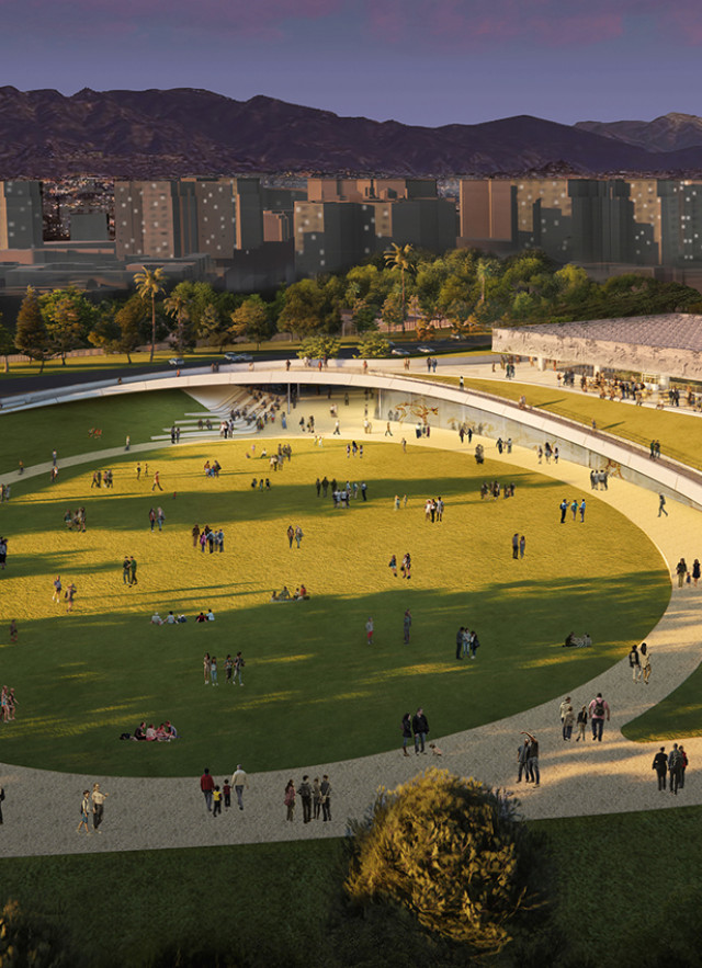 Aerial view of circular pathway on a green lawn, with mountains in the distance, at dusk