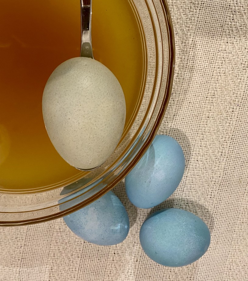 hard boiled eggs being dyed in spinach coloring 
