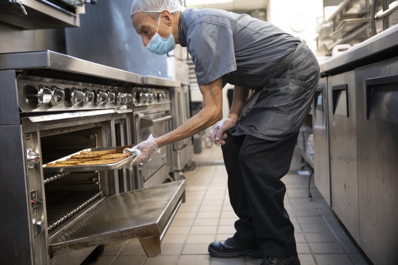 Man Pulling Bread out of oven 