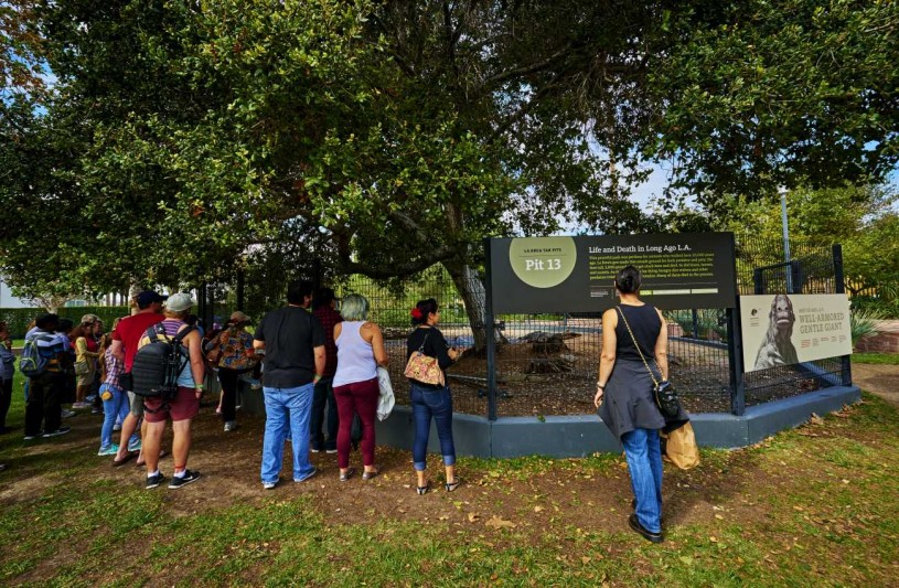 Visitors facing a fence and a Pit 13 sign